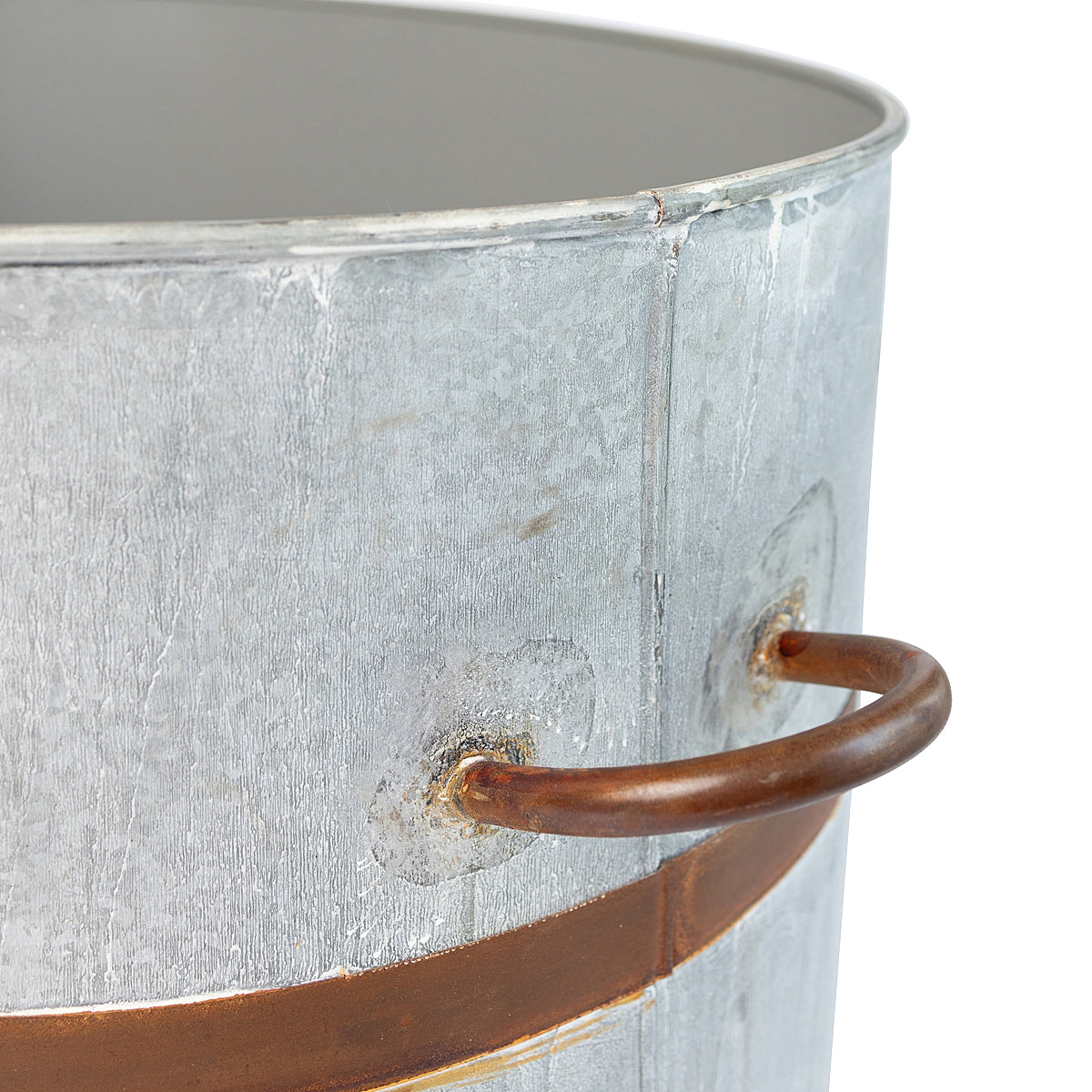 Close-up of a rustic oval water trough planter with a weathered finish and a distinctive rust-toned band, showcasing the details of the handle with a white background.