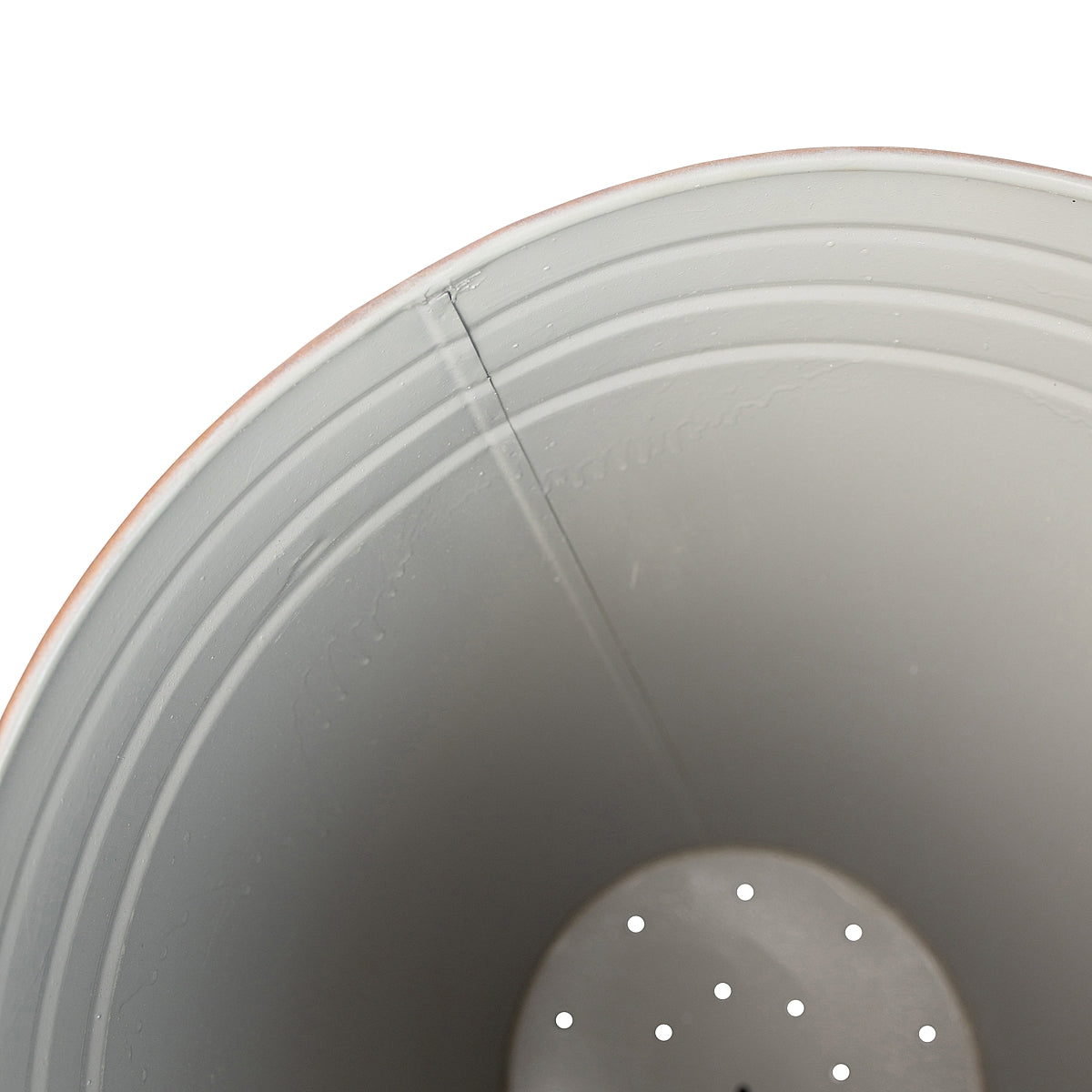 Close-up of inside of the Tall Weathered Whitewash Steel Planter showcasing the details and the drain holes on a white background.
