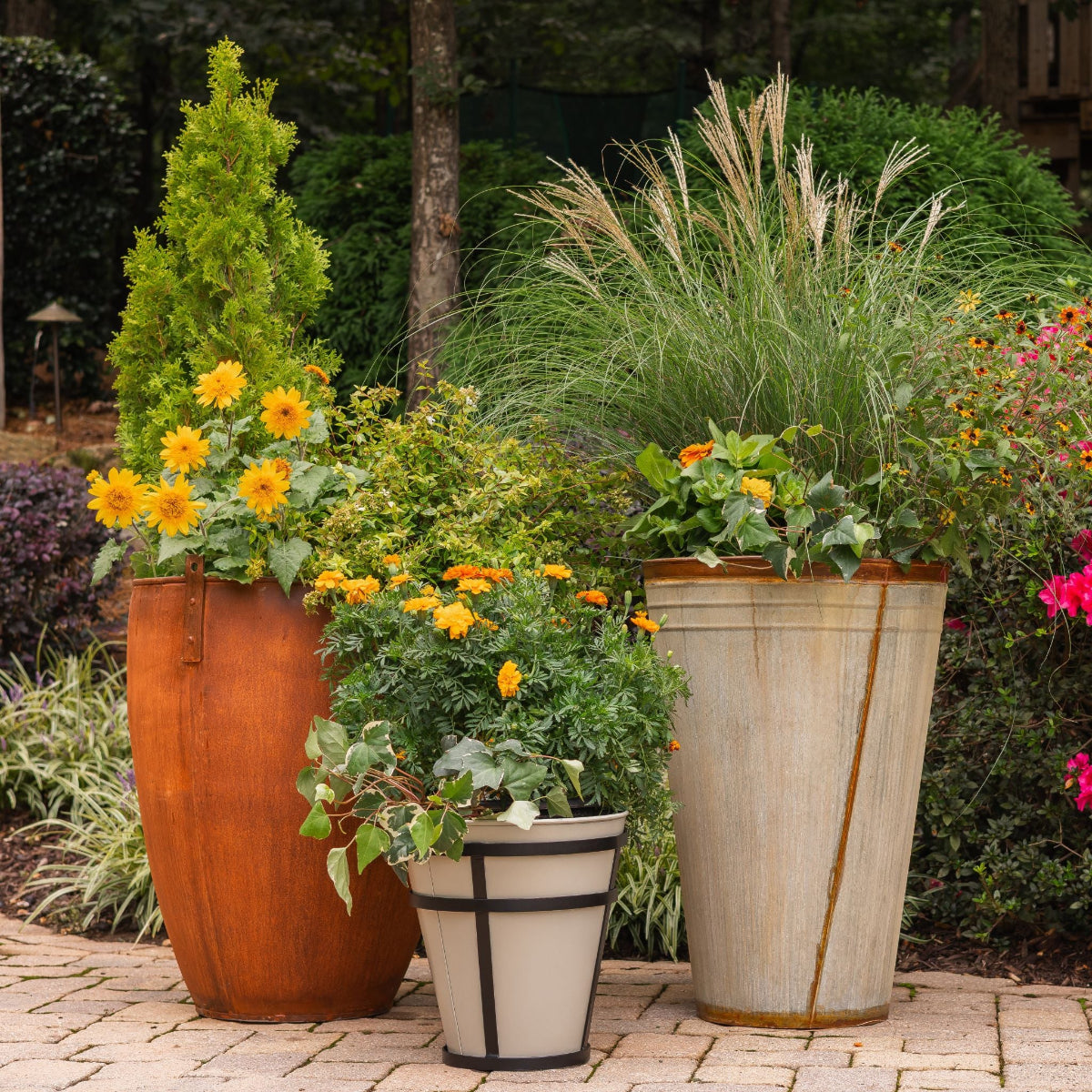Three Honey Bee Outdoor planters potted with beautiful flowers on a pool deck patio.