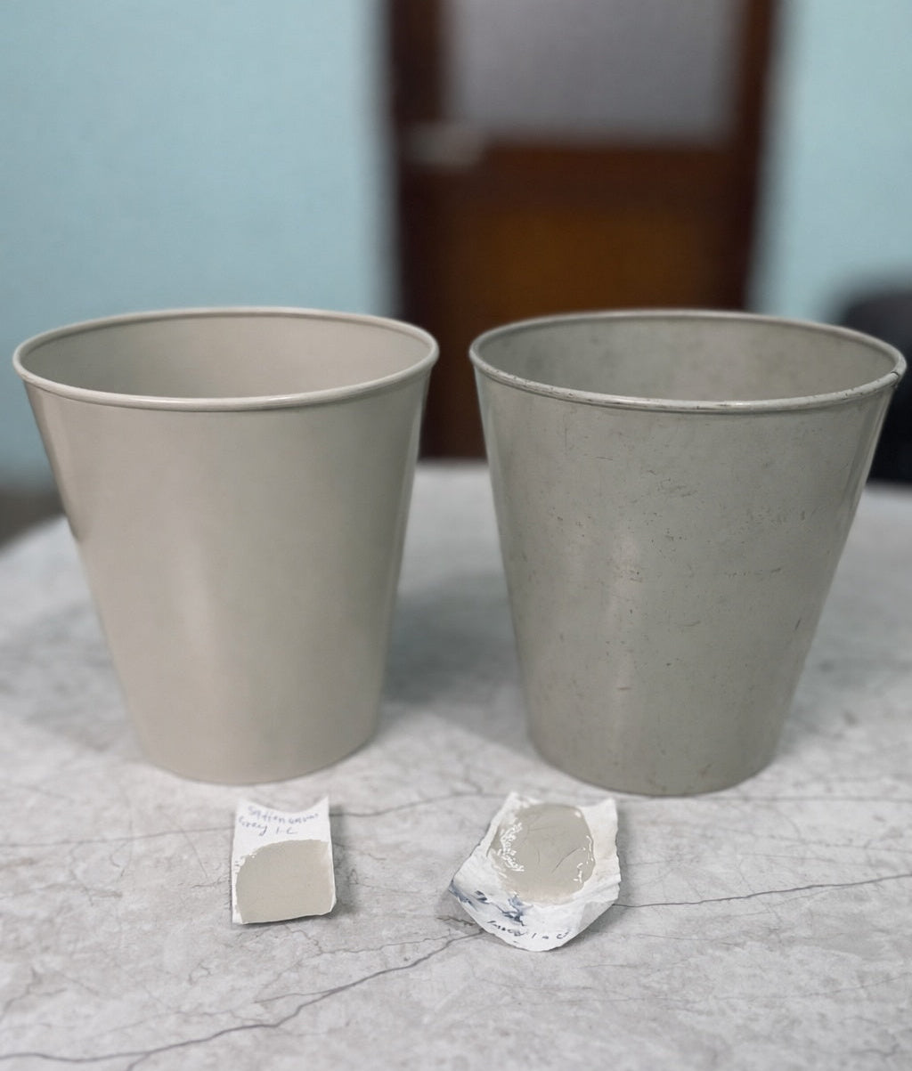 Two gray plant pots on a textured surface with small decorative items.